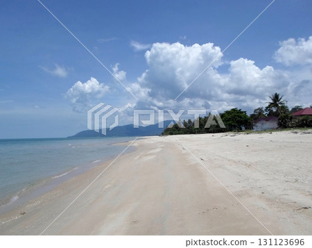 A Pristine Tropical Beach with Distant Mountains and Palm Trees Under a Partly Cloudy Sky A Pristine Tropical Beach with Distant Mountains and Palm Trees Under a Partly Cloudy Sky 131123696