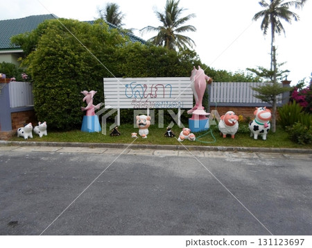 A Tropical Yard with Colorful Animal Statues and a Signboard Near Palm Trees on a Sunny Day A Tropical Yard with Colorful Animal Statues and a Signboard Near Palm Trees on a Sunny Day 131123697