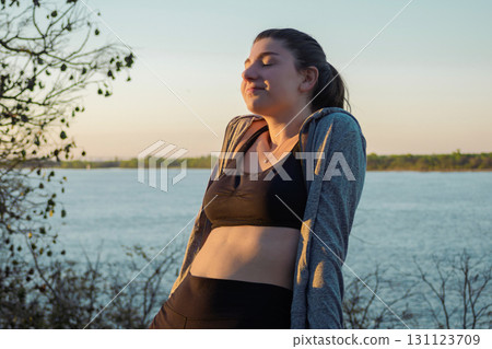 Caucasian girl relaxing in nature at sunset hour,balance, harmony and well-being 131123709