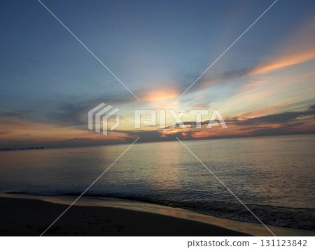 Quiet Beach with Gentle Waves Under Pastel Streaks of Sunset Sky Quiet Beach with Gentle Waves Under Pastel Streaks of Sunset Sky 131123842