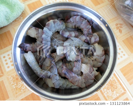 A Metal Bowl Filled with Fresh Raw Shrimp on a Checkered Tablecloth with a Green Towel A Metal Bowl Filled with Fresh Raw Shrimp on a Checkered Tablecloth with a Green Towel 131123864