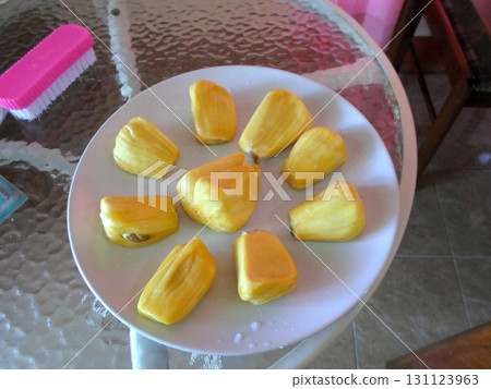 Sliced Jackfruit Pieces Arranged on a Plate on a Glass Table with a Brush Nearby 131123963