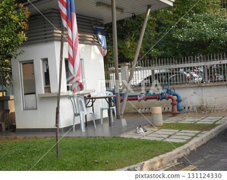 Guard Post with National Flags and Outdoor Seating Near a Roadside 131124330