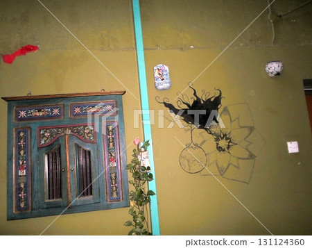 Courtyard Wall Decorated with a Painted Cabinet and Abstract Art Pieces 131124360