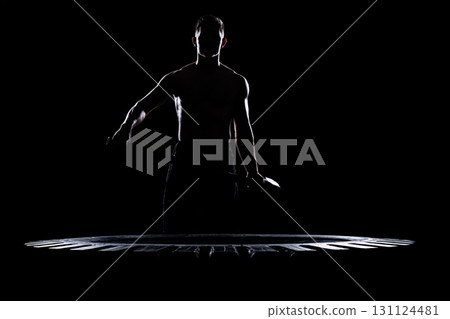 On a black background, you can see the outlines of a muscular man with a hammer. Tire and Hammer Training, Dark Key 131124481