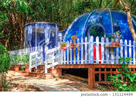 A blue dome-shaped house surrounded by green trees and a white fence. Sanya, China. A blue dome-shaped house surrounded by green trees and a white fence. Sanya, China. 131124494