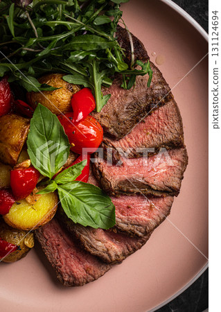 Grilled steak slices with potato tomato arugula 131124694