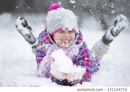 Happy girl throws snow. The child rejoices in winter and the first snow. Happy girl throws snow. The child rejoices in winter and the first snow. 131124719