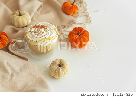 Cozy pumpkin latte with whipped cream and spices, surrounded by autumn decor. Cozy pumpkin latte with whipped cream and spices, surrounded by autumn decor. 131124829