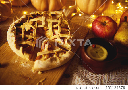 Autumn Lattice Pie With Fresh Fruit, Cozy Lights, And Thanksgiving Table Setting 131124878