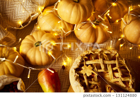 Autumn Thanksgiving Table With Mini Pumpkins, Apple, Pie, And Warm Fairy Lights 131124880