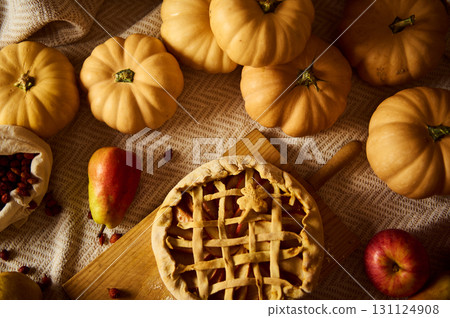 Autumn Harvest Scene With Pumpkins, Apples, and Lattice Pie on Rustic Table 131124908