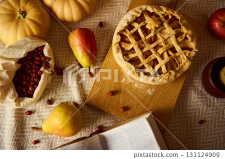 Autumn Table Scene With Pie, Pumpkins, Fruit, Cranberries, And Open Book 131124909