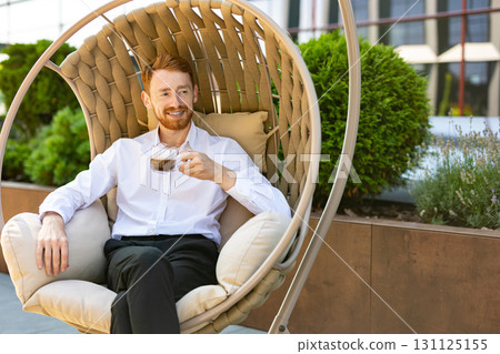 Bearded ginger man in business casual outfit drinking coffee in lounge space Bearded ginger man in business casual outfit drinking coffee in lounge space 131125155