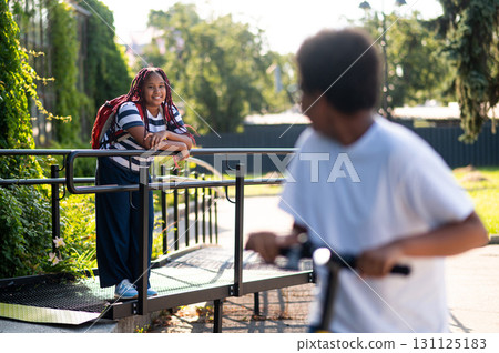 Teens in a park having fun while riding a scooter 131125183