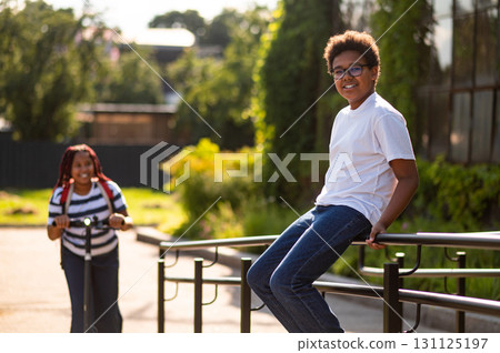 Teens talking on the bridge on a summer day and looking interested 131125197