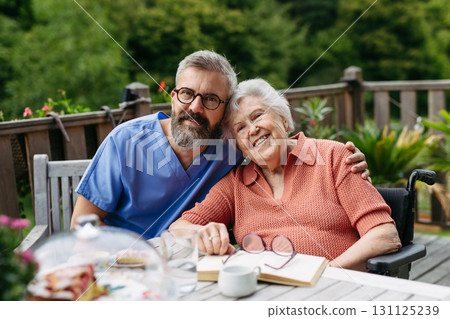 Caregiver spending time with elderly woman, drinking coffee and talking. Caregiver spending time with elderly woman, drinking coffee and talking. 131125239