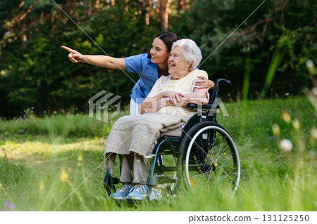 Home nurse taking care of elderly woman in wheelchair. 131125250