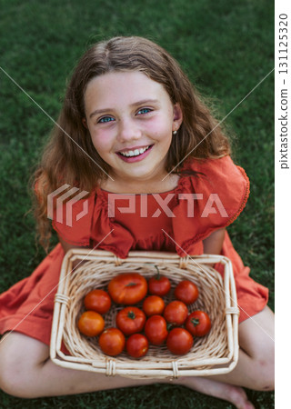 Cute girl with basket full of tomatoes. Cute girl with basket full of tomatoes. 131125320