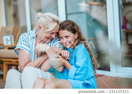 Grandmother and granddaughter spending summer together, sitting in front of house. Grandmother and granddaughter spending summer together, sitting in front of house. 131125321