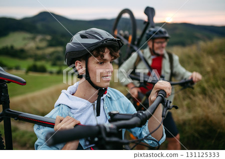 Older couple cycling together in nature, smiling and enjoying outdoor adventure. Older couple cycling together in nature, smiling and enjoying outdoor adventure. 131125333