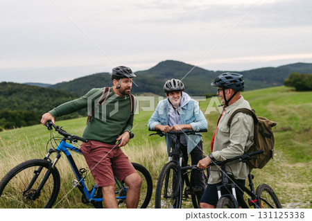 Grandfather, father and teen boy on cycling trip taking selfie. Grandfather, father and teen boy on cycling trip taking selfie. 131125338
