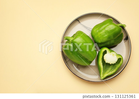 Green sweet pepper bell on plate on beige background. 131125361