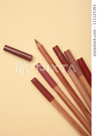 Different lip pencils on beige background. Cosmetic product. Vertical photo Different lip pencils on beige background. Cosmetic product. Vertical photo 131125363