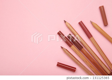 Different lip pencils on pink background. Cosmetic product Different lip pencils on pink background. Cosmetic product 131125365