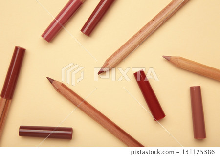 Different lip pencils on beige background. Cosmetic product Different lip pencils on beige background. Cosmetic product 131125386