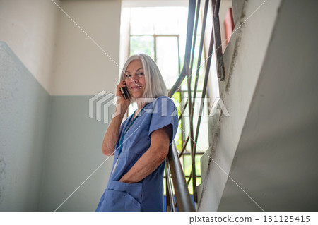 Tired nurse taking break during hospital shift, calling with family. Tired nurse taking break during hospital shift, calling with family. 131125415