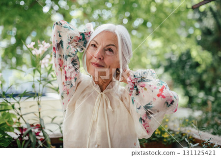 Portrait of beautiful senior woman standing on balcony. Portrait of beautiful senior woman standing on balcony. 131125421