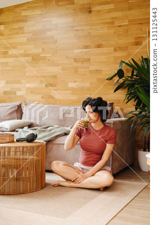 Portrait of woman with hair rollers during slow morning. 131125443