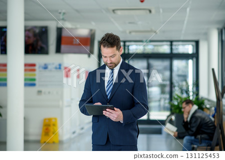 Business professional standing with tablet in hand, ready for presentation Business professional standing with tablet in hand, ready for presentation 131125453