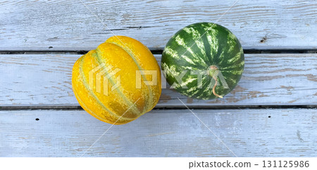 small melon and watermelon lying on wooden surface, home garden vegetable garden 131125986