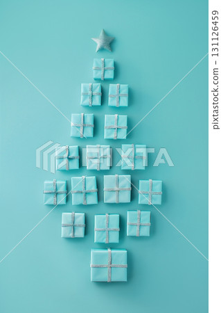 Christmas presents arranged in a tree shape on a turquoise background with copy space for text 131126459