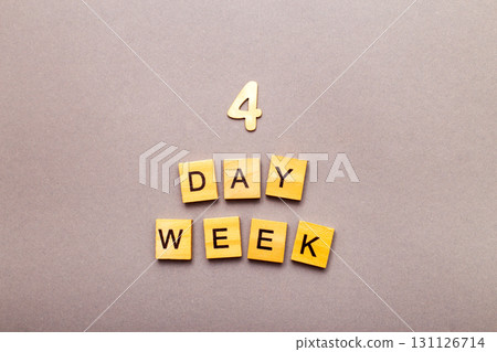 inscription four day week making by wooden cubes on grey background inscription four day week making by wooden cubes on grey background 131126714