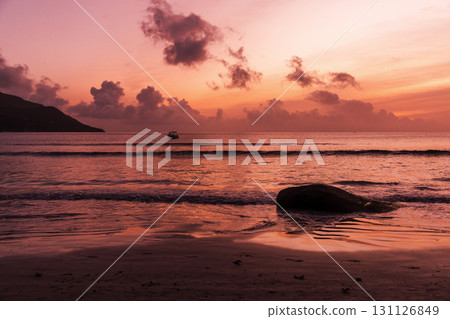 A picturesque beach scene featuring smooth rocks and calm water 131126849