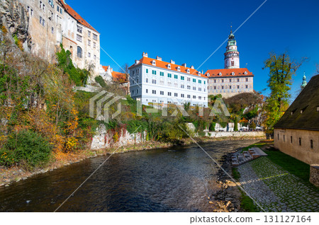 Panoramic view of Cesky Krumlov, featuring the historic castle tower and the church of St. John of Nepomuk. The medieval town's charm is beautifully captured on a sunny day 131127164