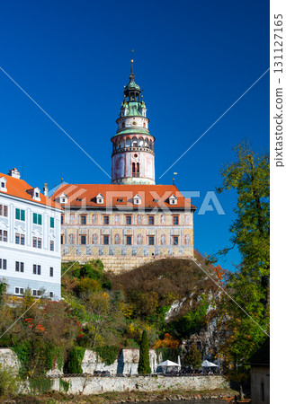 Panoramic view of Cesky Krumlov, featuring the historic castle tower and the church of St. John of Nepomuk. The medieval town's charm is beautifully captured on a sunny day 131127165