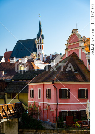 Church of St. Vitus in Cesky Krumlov surrounded by the historic town center. A sunny day with a clear blue sky highlights the charm of this UNESCO-listed medieval destination 131127166
