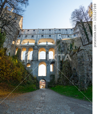 Cloak Bridge in Cesky Krumlov captured at sunset, with warm light illuminating the historic architecture. A stunning view of this UNESCO site during a tranquil evening Cloak Bridge in Cesky Krumlov captured at sunset, with warm light illuminating the historic architecture. A stunning view of this UNESCO site during a tranquil evening 131127169