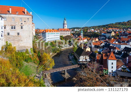 Panoramic view of Cesky Krumlov, showcasing the UNESCO-listed historic center surrounded by the Vltava River in a meander. A sunny autumn day highlights the town's charm. 131127170