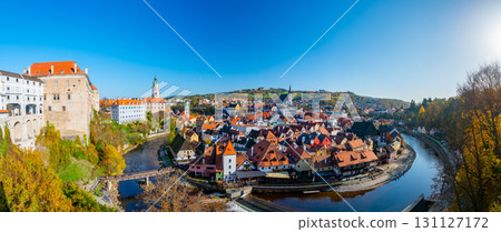 Panoramic view of Cesky Krumlov, showcasing the UNESCO-listed historic center surrounded by the Vltava River in a meander. A sunny autumn day highlights the town's charm. Panoramic view of Cesky Krumlov, showcasing the UNESCO-listed historic center surrounded by the Vltava River in a meander. A sunny autumn day highlights the town's charm. 131127172