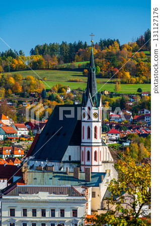 Church of St. Vitus in Cesky Krumlov surrounded by the historic town center. A sunny day with a clear blue sky highlights the charm of this UNESCO-listed medieval destination 131127176