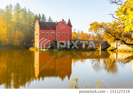 Panoramic view of Cervena Lhota Castle in the Czech Republic, surrounded by a lake reflecting its image. Autumn trees in vibrant colors and sunny weather create a picturesque, serene scene. Panoramic view of Cervena Lhota Castle in the Czech Republic, surrounded by a lake reflecting its image. Autumn trees in vibrant colors and sunny weather create a picturesque, serene scene. 131127219