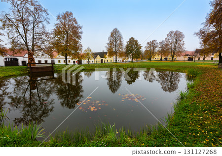 Medieval houses, farms, and granaries of Holasovice village in South Bohemia, arranged around a park with ponds. A UNESCO World Heritage Site showcasing rural baroque architecture Medieval houses, farms, and granaries of Holasovice village in South Bohemia, arranged around a park with ponds. A UNESCO World Heritage Site showcasing rural baroque architecture 131127268