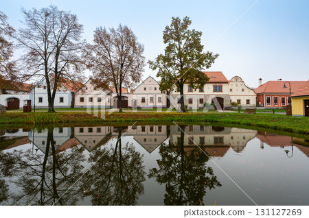 Medieval houses, farms, and granaries of Holasovice village in South Bohemia, arranged around a park with ponds. A UNESCO World Heritage Site showcasing rural baroque architecture Medieval houses, farms, and granaries of Holasovice village in South Bohemia, arranged around a park with ponds. A UNESCO World Heritage Site showcasing rural baroque architecture 131127269