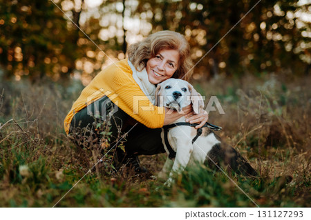 Older woman with his dog in autumn nature. 131127293