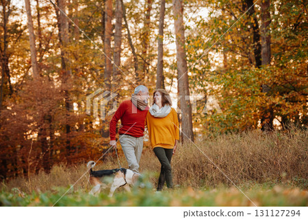 Senior couple walking dog in autumn forest. Senior couple walking dog in autumn forest. 131127294